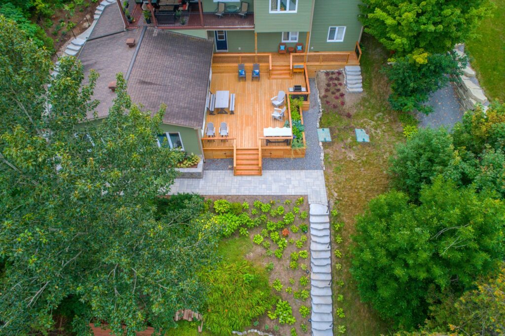 House with timber deck and a concrete paved garden